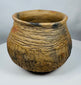 Hand-built Casas Grandes pottery jar dating to circa 1100–1450 CE, displaying traditional corrugated ceramic construction and warm buff coloration.
