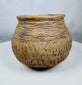 Historic Casas Grandes ceramic vessel from northern Mexico with wide mouth opening, corrugated shoulder bands, and mineral deposits.