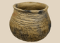 Ancient Casas Grandes corrugated pottery jar from northern Mexico featuring a globular body, wide mouth, and textured earthenware surface.