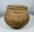 Pre-Columbian corrugated pottery jar attributed to the Casas Grandes culture, showcasing traditional utilitarian ceramic techniques and age-related wear.