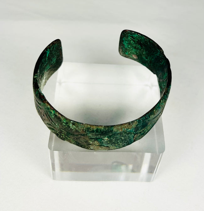 Museum-quality Persian bronze cuff bracelet displayed on clear stand