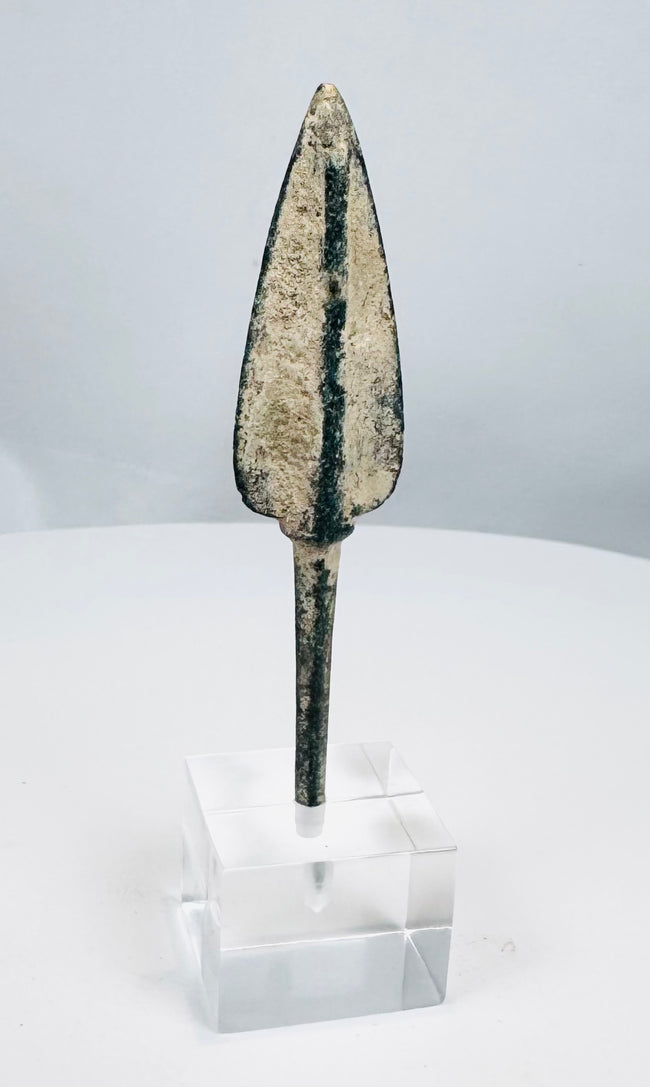 Ribbed lanceolate bronze projectile head with pale mineral encrustation
