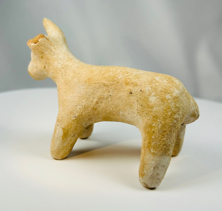 Iron Age Amlash terracotta bovine figure with compact body and raised head.
