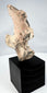 Pre-Columbian sculptural fragment with headdress, perforated eyes, and weathered surface