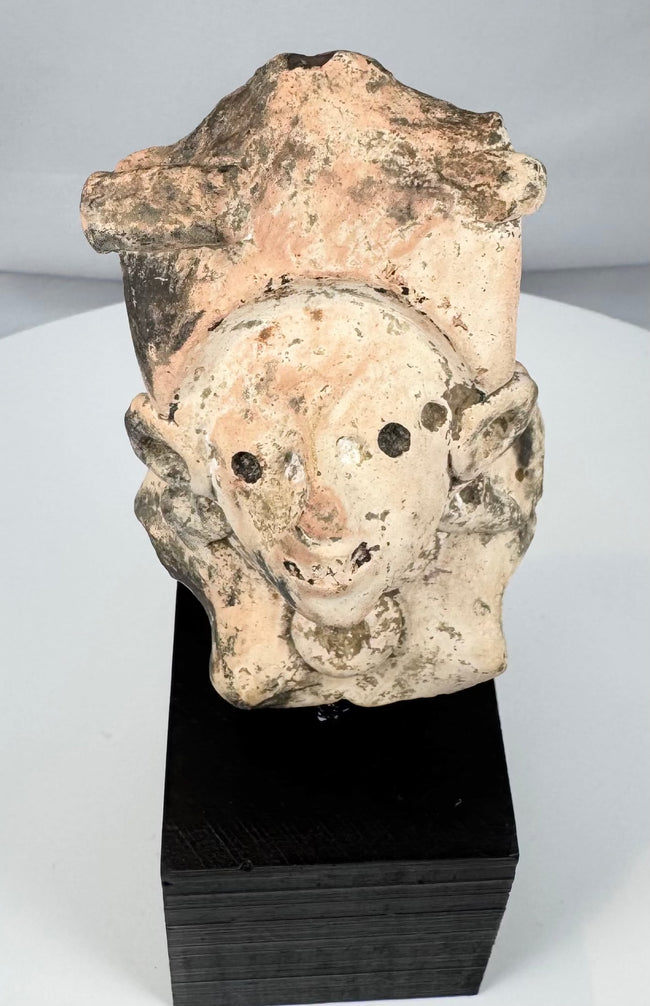 Mexican terracotta human figure fragment with abstract facial features and ceremonial ornaments
