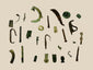 Collection of 28 ancient Roman bronze artifacts including amulets, handles, buttons, and decorative items, showing patina and wear, spanning 1st–12th century AD across Europe, North Africa, and the Near East.