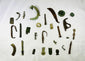 Collection of mixed Roman bronze relics displayed on a black background, featuring symbolic and utilitarian items