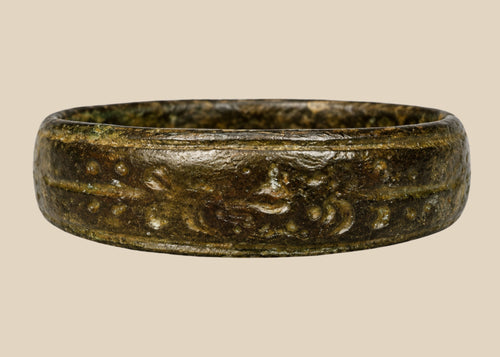 Ancient Roman bronze band ring, 1st–4th Century CE, featuring incised decorative motifs around the circumference. Worn as personal adornment and possibly symbolic of status or identity, with natural patina from centuries of age and use.