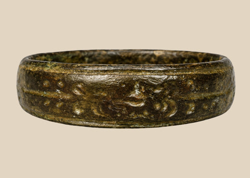 Ancient Roman bronze band ring, 1st–4th Century CE, featuring incised decorative motifs around the circumference. Worn as personal adornment and possibly symbolic of status or identity, with natural patina from centuries of age and use.