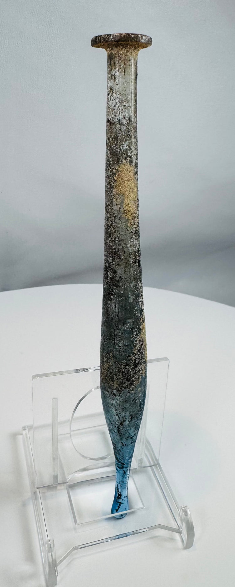 Ancient Roman pale blue glass candlestick unguentarium displaying archaeological weathering and iridescence