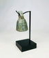 Detailed photograph of Roman bronze bell with worn surface and intact suspension loop.