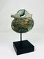 Full artifact image of ancient Roman bronze pendant with helmeted soldier iconography.