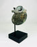 Detailed photograph of Roman bronze pendant featuring military or religious imagery.