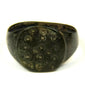 Roman bronze finger ring featuring irregular ring-and-dot decoration across the flat bezel