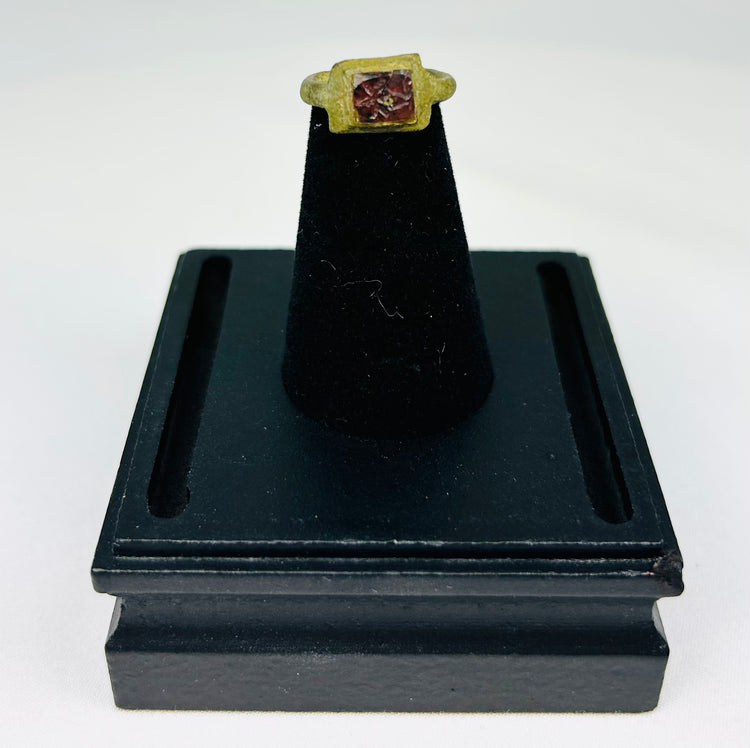 Ancient Roman bronze ring with inset red glass intaglio mounted for display
