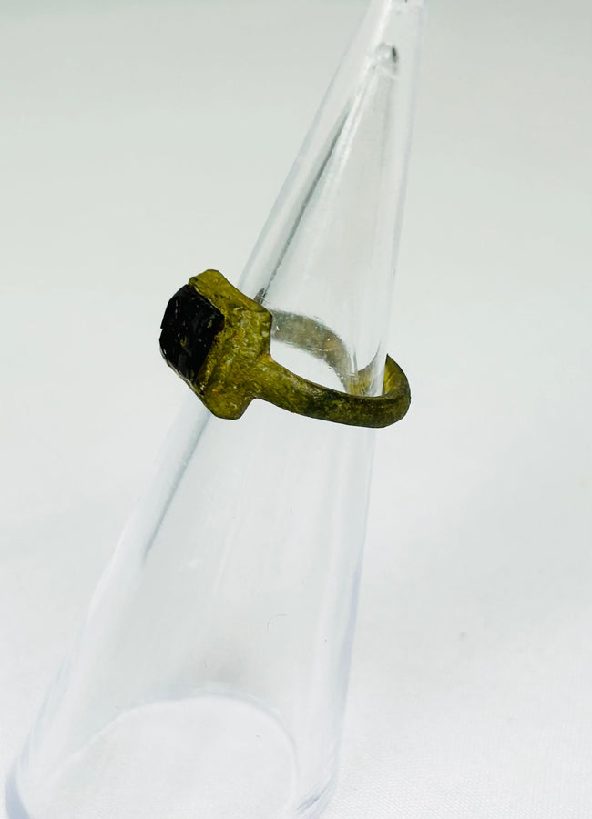 Historic Roman jewelry artifact displayed on museum-style black presentation stand