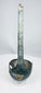 Side view of ancient bronze ladle showing long slightly curved handle