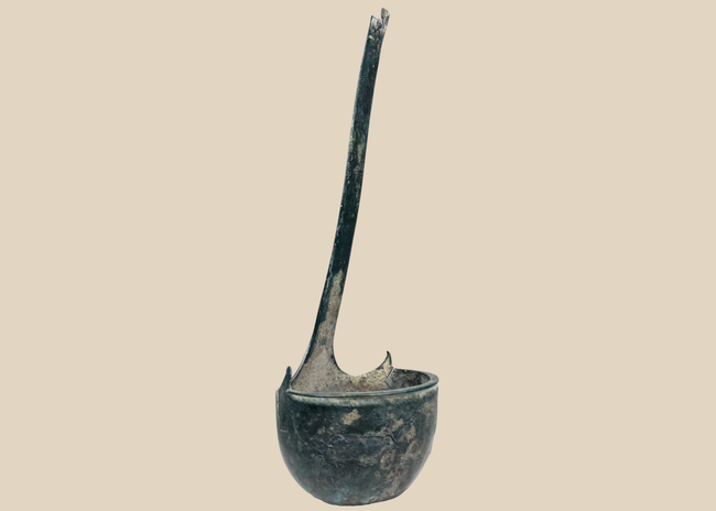 Ancient Roman bronze simpulum ladle with deep bowl and long curved handle