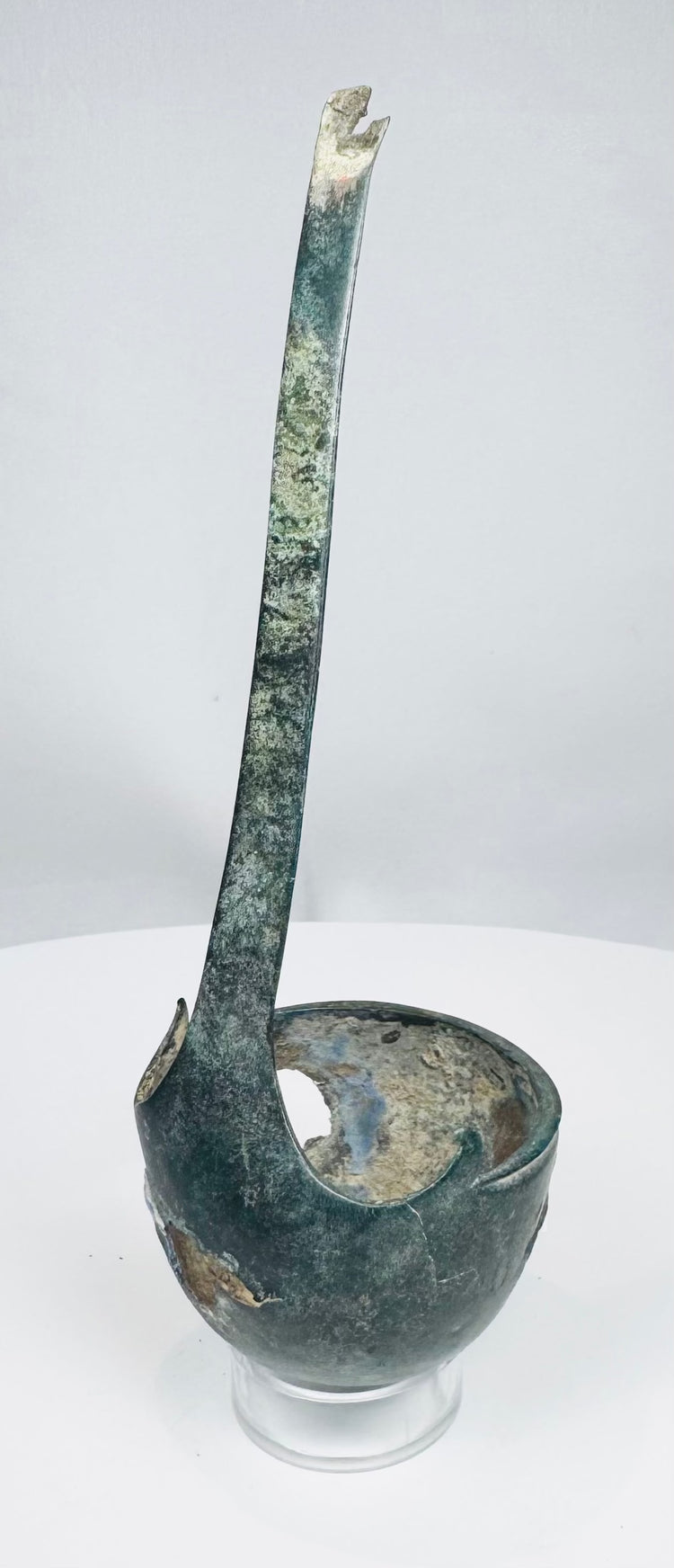 Close-up of Roman ladle bowl with corrosion, perforations, and mineral deposits