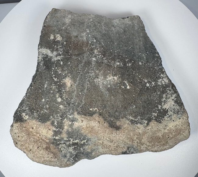 Carved Roman volcanic tuff relief fragment displaying porous stone grain, sculptural erosion and mineral encrustation