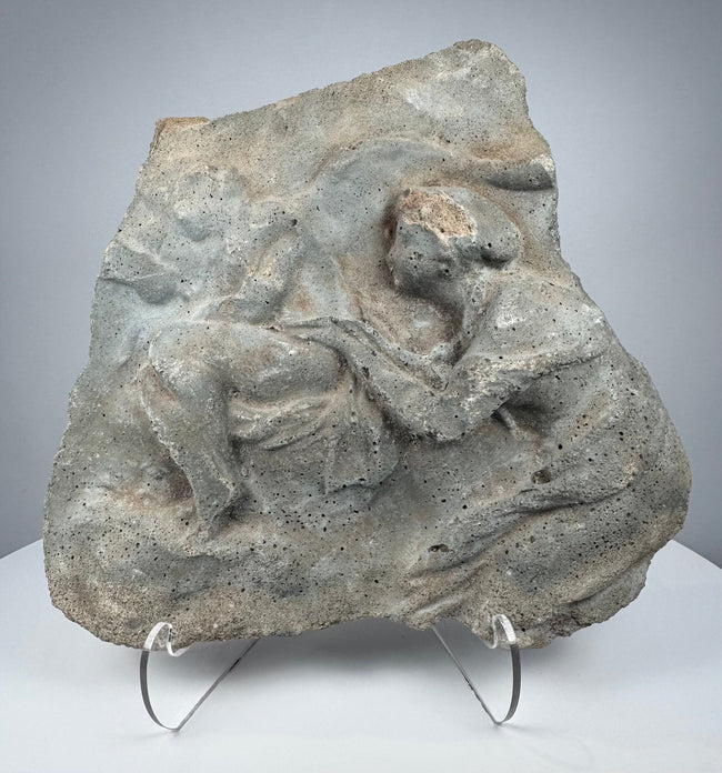 Ancient Roman carved stone relief depicting two Classical figures in deeply weathered volcanic tuff