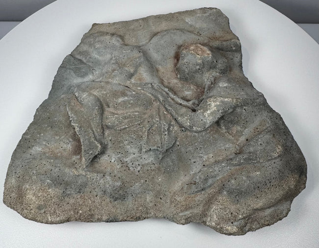 Ancient Roman stone relief showing surviving Classical figures, carved drapery and extensive surface weathering