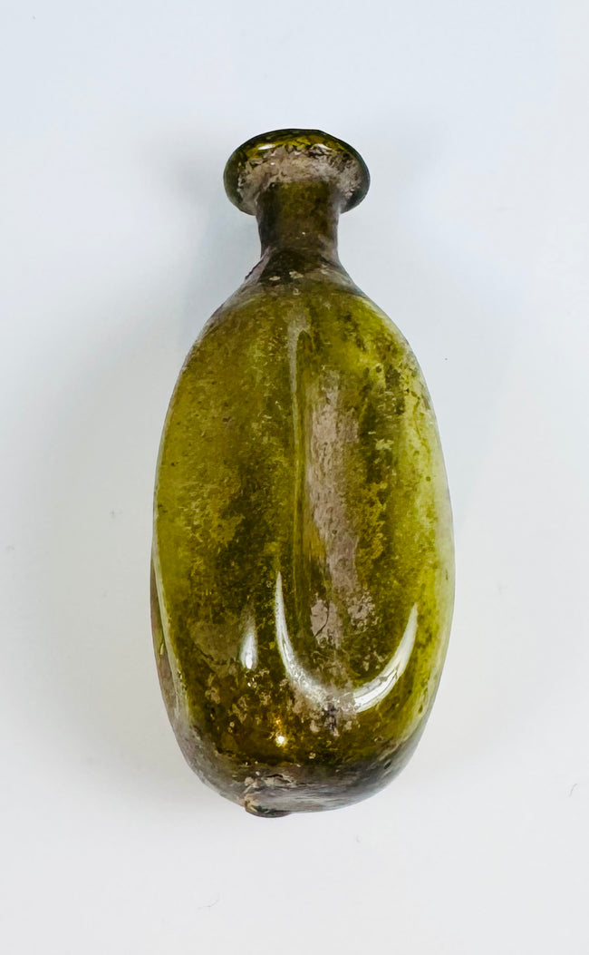 Ancient hand-blown Roman glass flask with fluted body and naturally weathered olive green surface