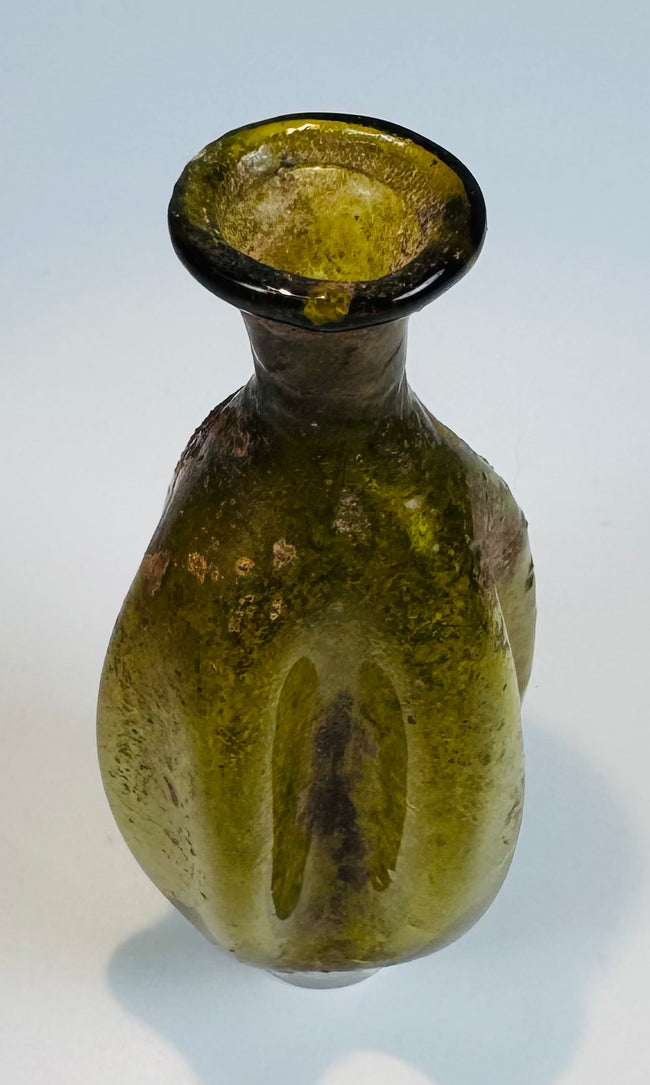 Roman Imperial period olive green glass container with distinctive vertically fluted design