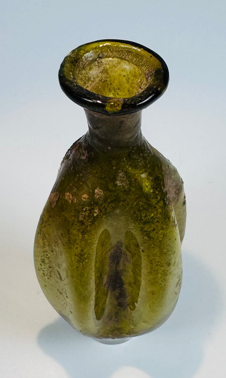 Roman Imperial period olive green glass container with distinctive vertically fluted design