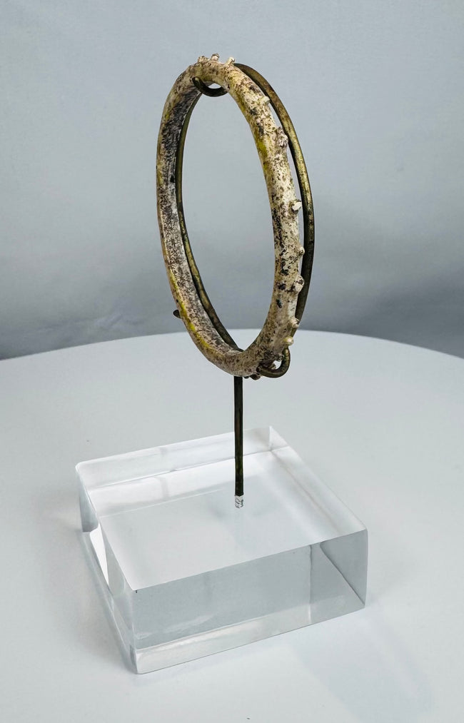 Historic Roman glass jewelry artifact with raised decorative elements and complete form.
