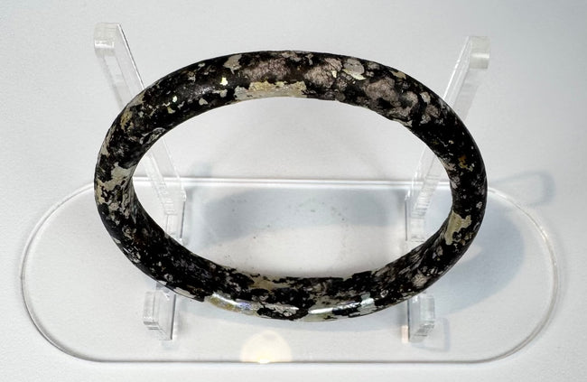 Ancient Roman glass bracelet showing dark cobalt or near-black glass beneath surface weathering