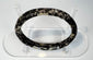 Ancient Roman glass bracelet showing dark cobalt or near-black glass beneath surface weathering