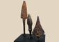 Three ancient Roman iron projectile points mounted on a black display base