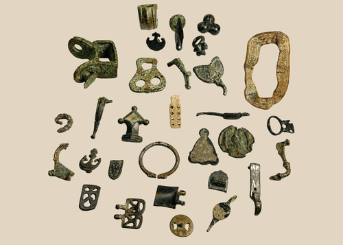 Collection of 31 ancient Roman bronze artifacts including belt mounts, harness fittings, buckles, spearhead fragment, and decorative mounts dating to the Roman Empire (1st–4th century CE