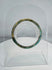 Ancient Roman polychrome glass bracelet displaying intricate striped decoration and archaeological iridescence.