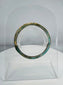 Ancient Roman polychrome glass bracelet displaying intricate striped decoration and archaeological iridescence.