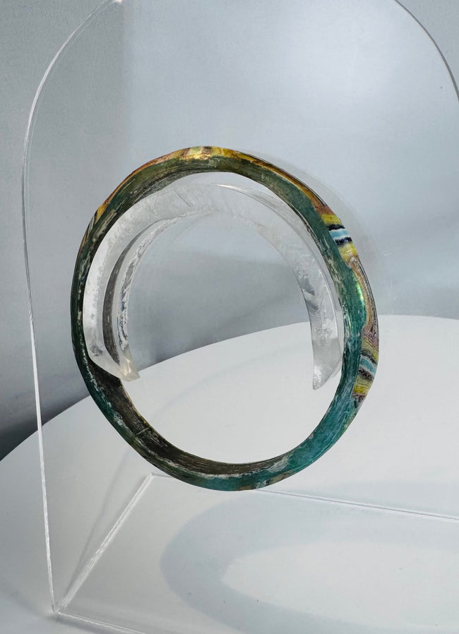 Ancient Roman personal adornment crafted from mosaic glass with surviving green, yellow, blue, and white decoration.