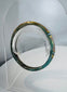 Ancient Roman personal adornment crafted from mosaic glass with surviving green, yellow, blue, and white decoration.
