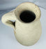 Side profile of an Ancient Roman terracotta pitcher showing the loop handle, neck, and rounded body.