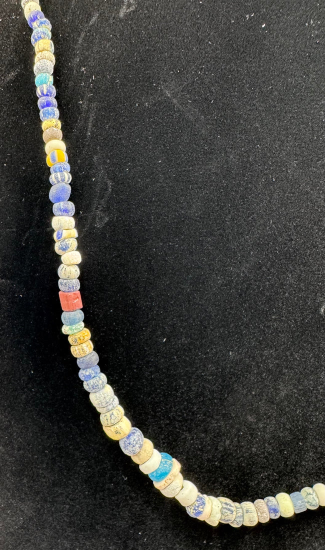 Roman Imperial glass beads displaying striped decoration and surface iridescence
