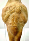 Detail of rough hand-formed terracotta texture with carved arm lines and central symbol
