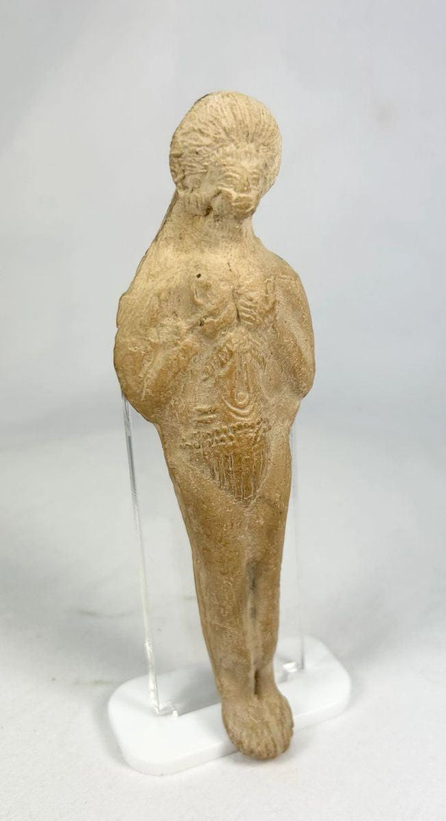 Close-up of hand-formed Roman terracotta figurine showing facial features and incised detailing.