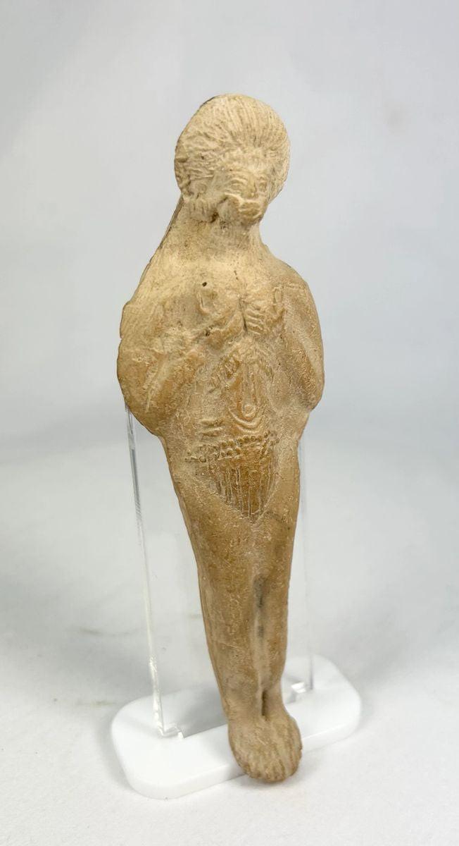 Close-up of hand-formed Roman terracotta figurine showing facial features and incised detailing.