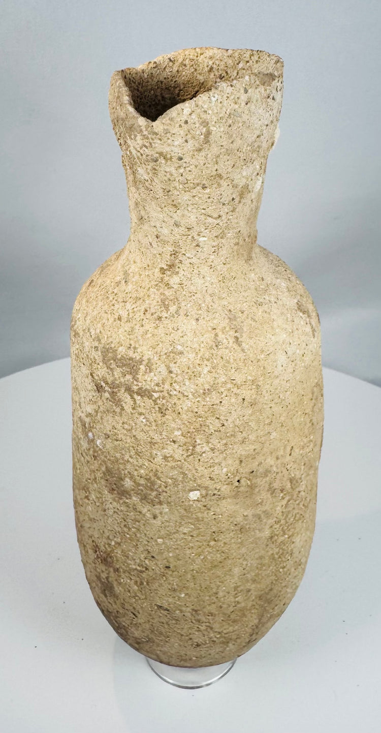 Side view of an ancient Roman Provincial terracotta pouring vessel highlighting its globular form and flared rim.