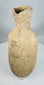Side view of an ancient Roman Provincial terracotta pouring vessel highlighting its globular form and flared rim.
