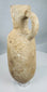 Ancient Mediterranean terracotta pouring jar displaying coarse buff-colored clay and natural mineral deposits.