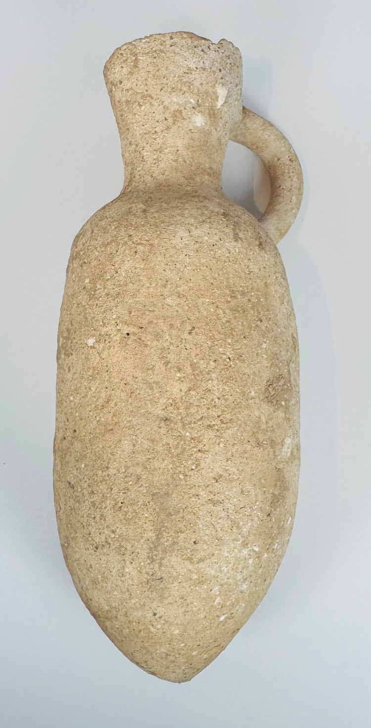 Close-up of the neck and handle of an ancient Mediterranean terracotta vessel with centuries of natural weathering.