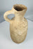 Ancient terracotta ceramic pouring vessel from the Mediterranean featuring a flared rim and rounded base.