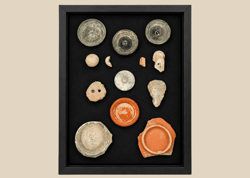 Comparative archaeological shadow-box showing ancient glass, ceramics, and stone artifacts