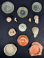 Roman glass vessel bases and terra sigillata fragments mounted in a wooden shadow-box frame